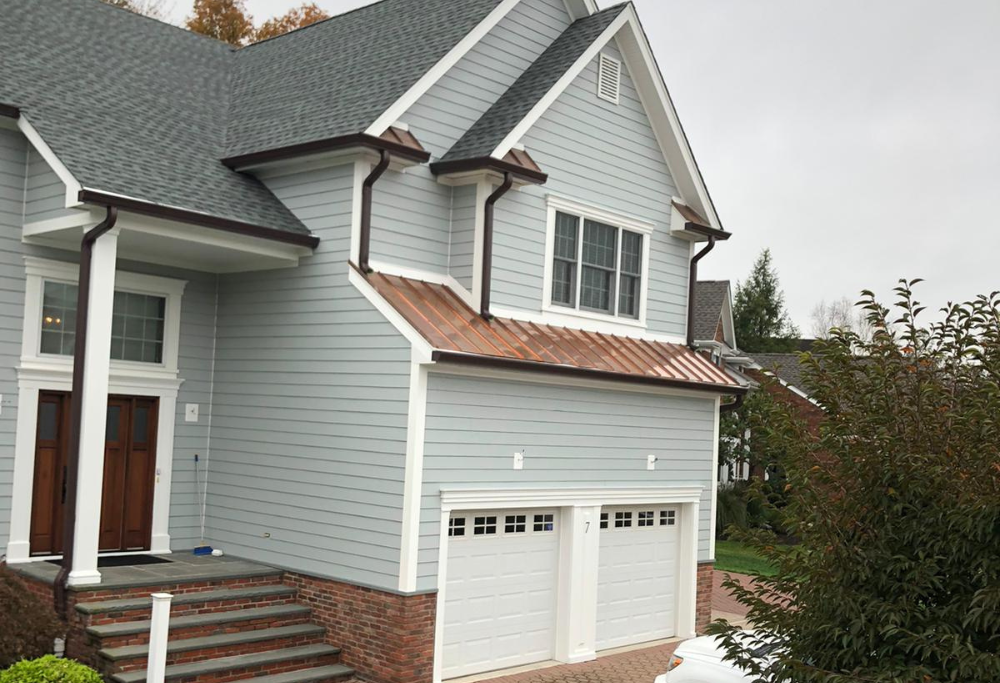 Side view of Classic gray siding, new roof, and hardscaping on a new construction home, courtesy of Lasting Construction LLC.